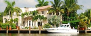 Scott Rivelli Home Slider Image of a waterfront home in South Florida with a yacht docked outside