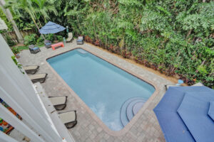 Pool view from Unit B balcony overlooking tropical landscaping at 624 NE 29th Drive.