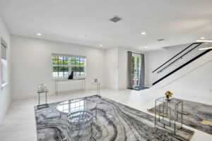 Spacious living room with modern design and glass staircase in Unit A, 624 NE 29th Drive, Wilton Manors.